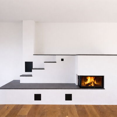 Speicherofen mit Brunner HKD Siebeneck-Kamin und gemauerten Speicherzügen für angenehme Strahlungswärme im Wohnraum.