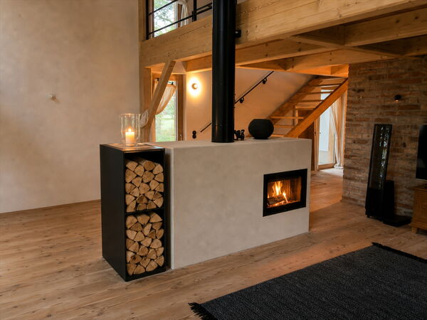 Grundofen mit sichtbarem Feuer und integrierter Rohstahl-Holzlege